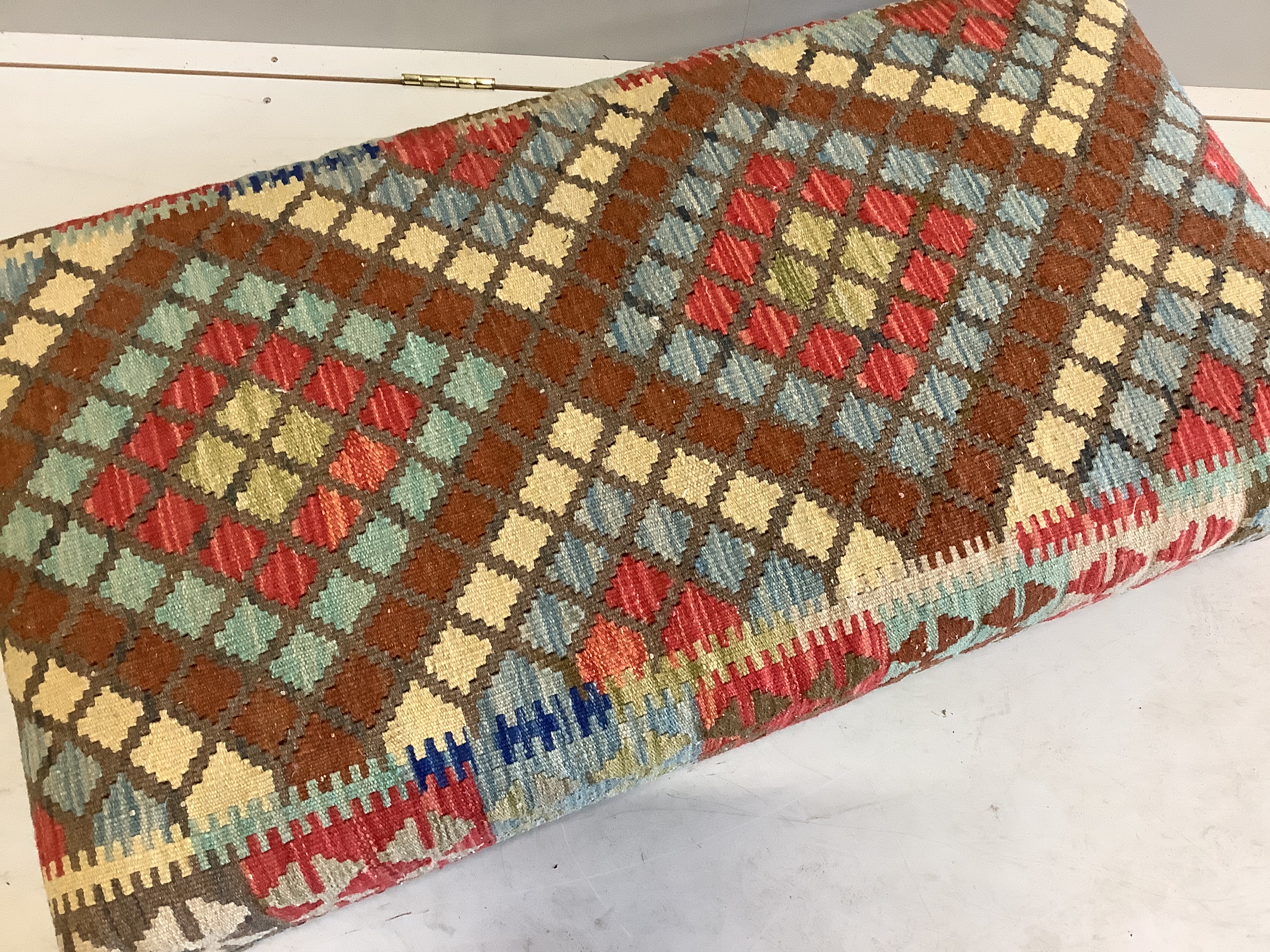 A rectangular Kilim footstool, on oak feet width 111cm, depth 60cm, height 25cm